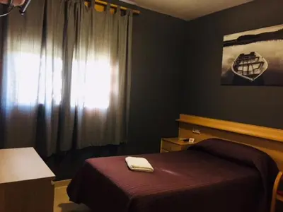 a bedroom with a bed and a window with a towel on it at Hostal del Carmen in Terrassa