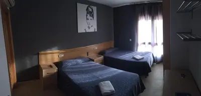 a room with two beds and a window at Hostal del Carmen in Terrassa