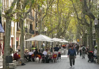 a crowd of people walking down a street with trees at RAMBLA POBLENOU Luxury in Barcelona
