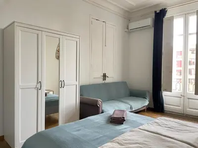 a living room with a bed and a couch at Grand Central Apartment in Barcelona