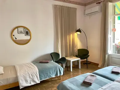 a hotel room with two beds and a mirror at Grand Central Apartment in Barcelona