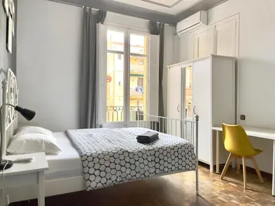 a bedroom with a bed and a desk and a yellow chair at Grand Central Apartment in Barcelona