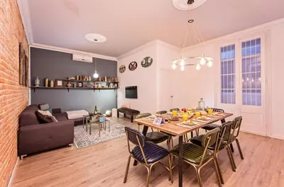 a dining room and living room with a table and chairs at Sweett - La Pedrera - Paseo de Gracia in Barcelona