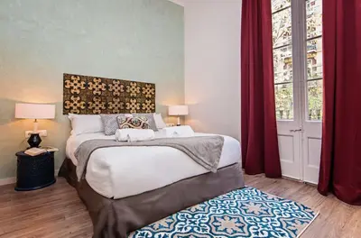 a bedroom with a large bed with red curtains at Sweett - La Pedrera - Paseo de Gracia in Barcelona