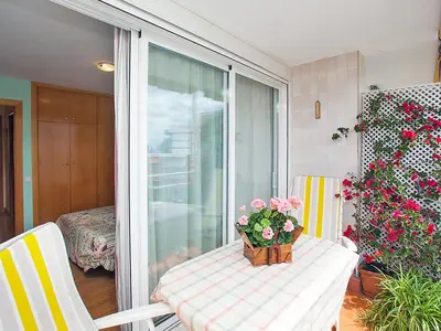 a table with a vase of flowers on a balcony at Apartment Mariola by Interhome in Sant Andreu de Llavaneres