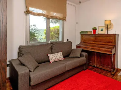 a living room with a couch and a piano at Holiday Home Ginesteres by Interhome in Argentona