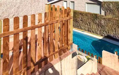 a wooden fence next to a swimming pool at Gorgeous Home In Alella in Alella