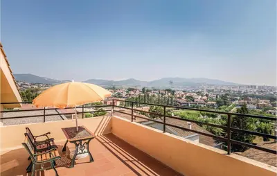 a balcony with two chairs and an umbrella at Gorgeous Home In Alella in Alella