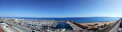 a beach with a large crowd of people and the water at Marina Port & Beach-Apartment in Masnou