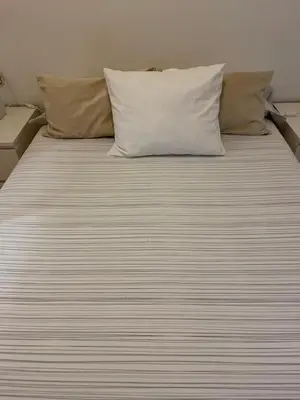 a bed with two pillows and a white bedsheet at Channing Apartment in Barcelona