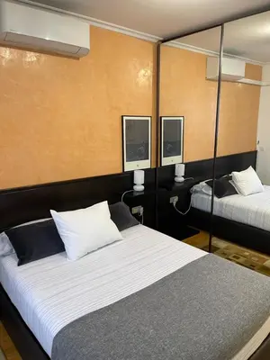 a bedroom with two beds and two mirrors at Channing Apartment in Barcelona