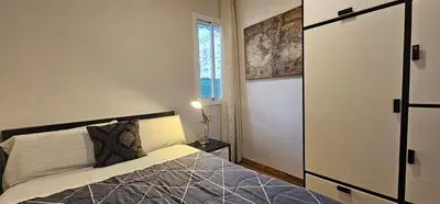 a small bedroom with a bed and a window at Penthouse in Sagrada Familia in Barcelona