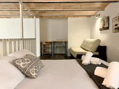 a bedroom with a bed and a chair at Dalí Residence in Barcelona