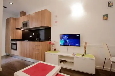 a living room with a tv and a kitchen at Dalí Residence in Barcelona