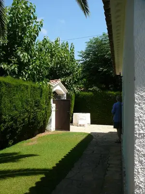a person walking down a sidewalk next to a house at Sunway Torre La Veleta in Sitges