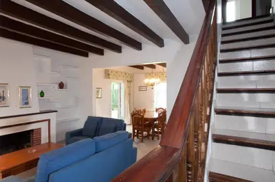 a living room with blue chairs and a staircase at Sunway Torre La Veleta in Sitges