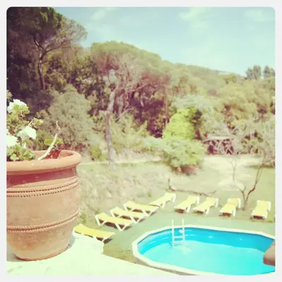 a pool with chairs and a potted plant and a pot at Can plana de baix in San Pol de Mar