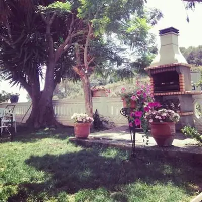 a yard with two pots of flowers and a gazebo at Can plana de baix in San Pol de Mar