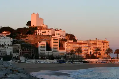 a group of buildings on a hill next to a beach at Can plana de baix in San Pol de Mar