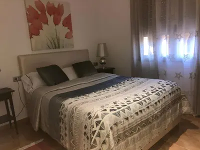 a bedroom with a bed with a white comforter at Apartamento Mar y Montaña in Argentona