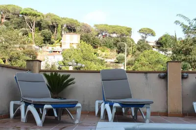 two chairs sitting on a balcony with a view of trees at Apartamento Mar y Montaña in Argentona