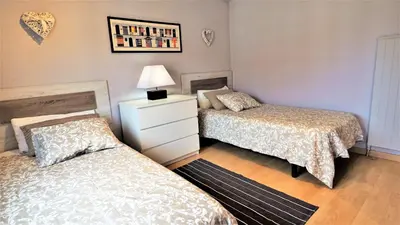 a bedroom with two beds and a dresser with a lamp at Helena Seaview & Beach-apartment in Montgat