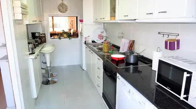 a kitchen with black counter tops and white cabinets at Claire Seaview & Beach-apartment in Montgat