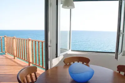 a dining room with a table and a view of the ocean at Apartamento en acantilado con wifi y aire acondicionado in Sitges