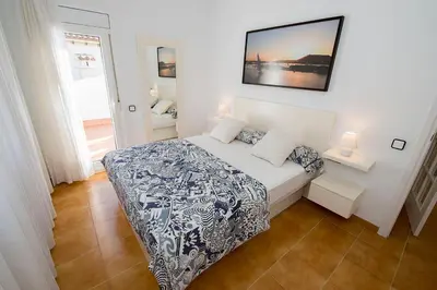 a bedroom with a bed with a blue and white comforter at Apartamento en acantilado con wifi y aire acondicionado in Sitges