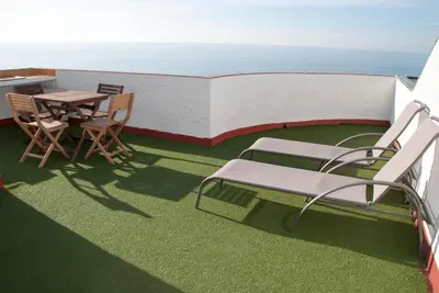 a balcony with a table and chairs and the ocean at Apartamento en acantilado con wifi y aire acondicionado in Sitges