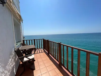 a balcony with a bench looking out at the ocean at Apartamento en acantilado con wifi y aire acondicionado in Sitges