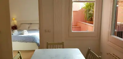 a bedroom with a bed and a table and a window at Filmoteca Sarria 1- wifi quiet bright comfi in Barcelona