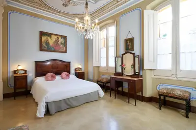 a bedroom with a bed and a chandelier at CAL PADRI1871 - 30min to Barcelona, Groups & Families, Beach Stylish House in Premiá de Mar