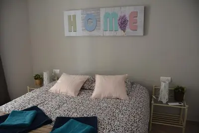 a bedroom with a bed with pillows and a sign on the wall at Apartamento Flavia II Sant Damià in Sitges