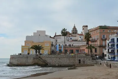 a group of buildings on a beach next to the ocean at Apartamento Flavia II Sant Damià in Sitges