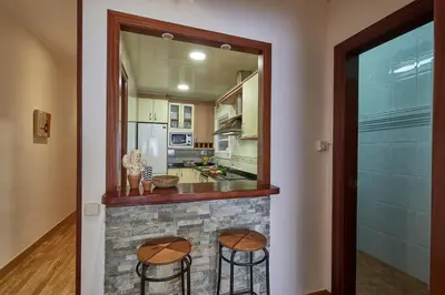 a kitchen with two stools and a stone fireplace at BBarcelona Gaudí Avenue Flat in Barcelona