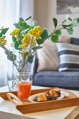 a tray with a plate of food and a drink on a table at BBarcelona Gaudí Avenue Flat in Barcelona