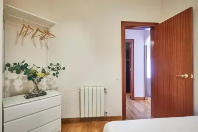 a bedroom with a dresser with a vase of flowers on it at BBarcelona Gaudí Avenue Flat in Barcelona