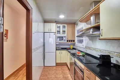 a kitchen with white appliances and wooden cabinets at BBarcelona Gaudí Avenue Flat in Barcelona