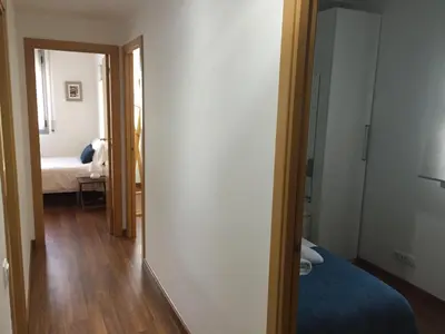 a room with a bed and a hallway with a mirror at Apartamento FIRA Barcelona in Hospitalet de Llobregat