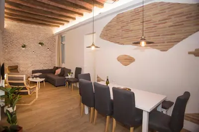 a dining room and living room with a table and chairs at Mai & Maud Ronda Apartment in Barcelona
