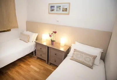 a bedroom with two beds and two lamps on a night stand at Mai & Maud Ronda Apartment in Barcelona