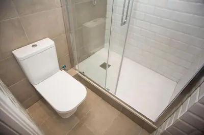 a bathroom with a toilet and a glass shower at Mai & Maud Ronda Apartment in Barcelona