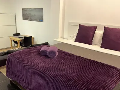 a bedroom with a purple bed with purple pillows at Apartahotel Baldiri in Sant Boi del Llobregat