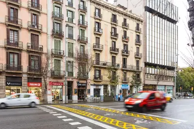 a red van driving down a city street with buildings at Casa Cosi Letamendi in Barcelona