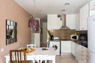 a kitchen with a white table and chairs at Casa Cosi Letamendi in Barcelona