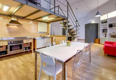 a kitchen and dining room with a white table and chairs at Camp Nou Apartment in Hospitalet de Llobregat