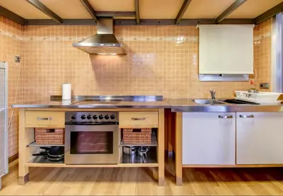 a kitchen with a counter with a sink and a stove at Camp Nou Apartment in Hospitalet de Llobregat