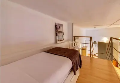 a bedroom with a bed with a brown blanket on it at Camp Nou Apartment in Hospitalet de Llobregat
