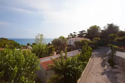 a view of a house with the ocean in the background at Apartment Beach Front Sant Pol in San Pol de Mar